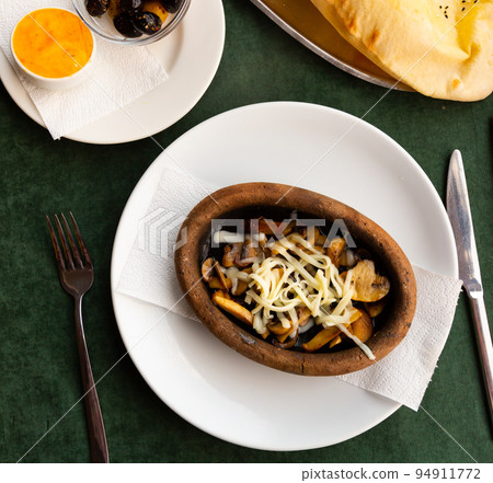 Sauteed champignons with shredded cheese served in Turkish restaurant 94911772