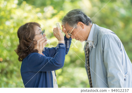 Wife combing her senior husband's hair 94912237