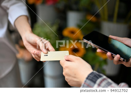 An Asian female customer paying her stuff with a credit card. Credit card payment concept An Asian female customer paying her stuff with a credit card. Credit card payment concept 94912702