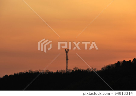 The sky dyed in the sunset and the radio tower 94913314