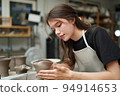 Beautiful woman making ceramic pottery on wheel, close-up. woman in freelance, business, hobby. 94914653