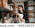 Beautiful woman making ceramic pottery on wheel, close-up. woman in freelance, business, hobby. 94914659