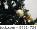 Golden ornaments on the Christmas tree 94914734