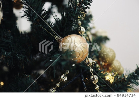 Golden ornaments on the Christmas tree Golden ornaments on the Christmas tree 94914734