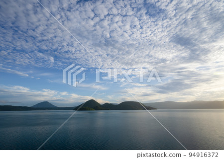白雲在洞爺湖的早晨陽光下在藍天中蔓延 白雲在洞爺湖的早晨陽光下在藍天中蔓延 94916372