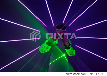 Woman is using virtual reality headset to access in metaverse. 94917193