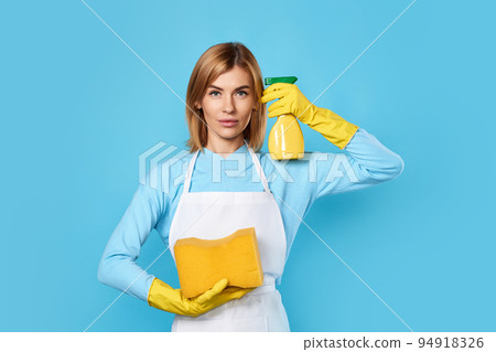 woman in rubber gloves holding detergent sprayer and pointing to head woman in rubber gloves holding detergent sprayer and pointing to head 94918326