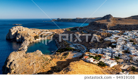 Traditional greek white buildings in town Lindos at Rhodes island in Greece. Sea at background Traditional greek white buildings in town Lindos at Rhodes island in Greece. Sea at background 94919108