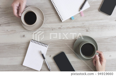 Two people drinking coffee while working. Chatting during work, coffee breaks, meetings, etc. 94919660