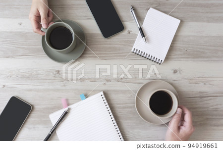 Two people drinking coffee while working. Chatting during work, coffee breaks, meetings, etc. 94919661