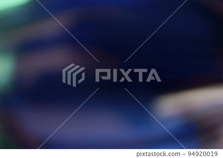 Lens flare overlay. Light leak. Blur glow. Defocused neon blue green orange color flecks texture on dark black abstract copy space background. 94920019