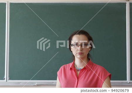 Woman in front of chalkboard 94920679