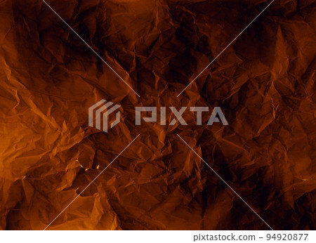 Crumpled paper. Worn texture. Weathered overlay. Crinkled noise on dark orange black rough grunge structure illustration abstract background. 94920877