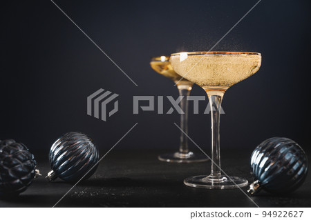 New Year champagne in wine glasses and bottle in bucket decorated Christmas blue baubles. New Year champagne in wine glasses and bottle in bucket decorated Christmas blue baubles. 94922627