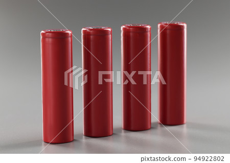 Red alloy batteries stand in a row on a gray background Red alloy batteries stand in a row on a gray background 94922802