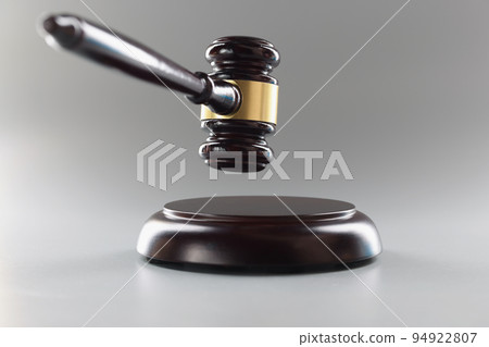 Brown wooden judge's gavel on a gray background Brown wooden judge's gavel on a gray background 94922807