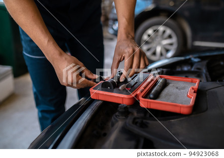 Mechanic selecting an optical tool for work Mechanic selecting an optical tool for work 94923068