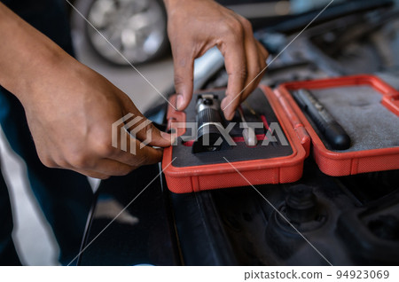 Experienced car service station worker choosing an optical device 94923069