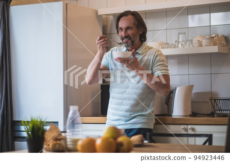 Mature man having breakfast and looking contented and peaceful 94923446