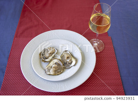 Oysters on a plate and a glass of white wine 94923931