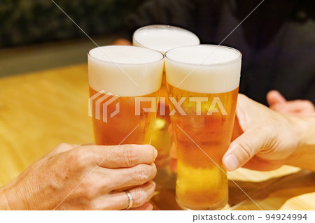 People toasting mug draft beer at a restaurant 94924994