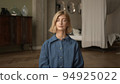 Woman doing breathing exercises, hands up, yoga practicing. Blonde attractive physical trainer in 94925022