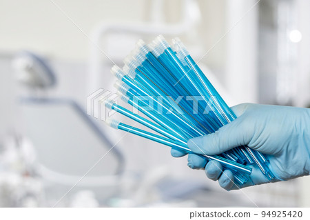 Dentist's hand in glove with saliva ejectors. Dentist's hand in glove with saliva ejectors. 94925420