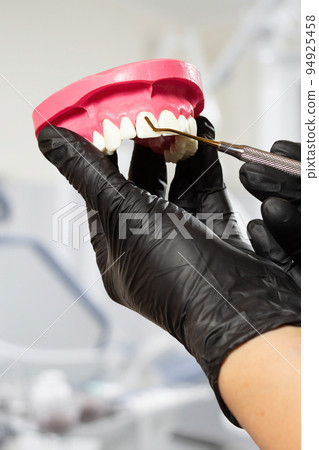 Dentist's hands with layout of human jaw and midical tool. Dentist's hands with layout of human jaw and midical tool. 94925458