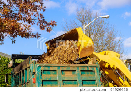 The municipality removes fallen leaves with excavators or on trucks near houses in autumn when the leaves fall into the roads The municipality removes fallen leaves with excavators or on trucks near houses in autumn when the leaves fall into the roads 94926626