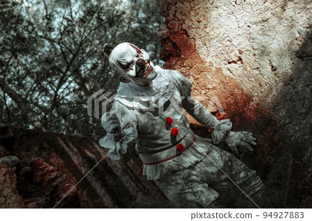 evil clown with a cleaver in an abandoned house 94927883