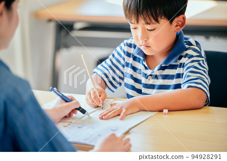 Elementary school boy writing in a notebook 94928291
