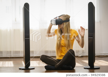 Girl wearing virtual reality goggles at home 94929386