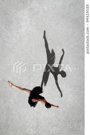 Portrait of young ballerina in black dress performing isolated over grey wall background. Top view. Shadow element. Twine Portrait of young ballerina in black dress performing isolated over grey wall background. Top view. Shadow element. Twine 94929589