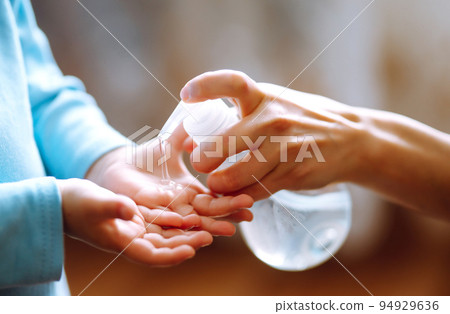 Hands with sanitizer gel. Mother and child using sanitize soap for hand coronavirus protection. Hands with sanitizer gel. Mother and child using sanitize soap for hand coronavirus protection. 94929636