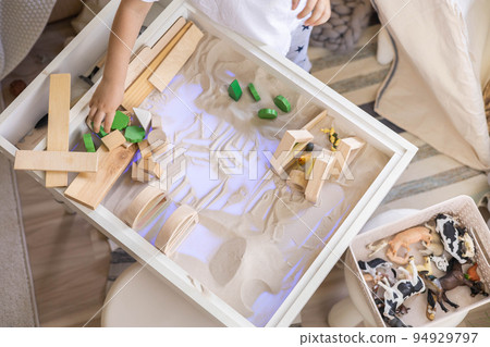 Cute male kid playing with sensory box kinetic sand table Montessori material wooden ecology toys 94929797