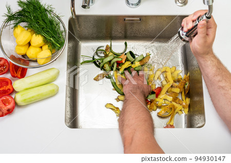 Modern sink with food waste in the hole of the disposer 94930147