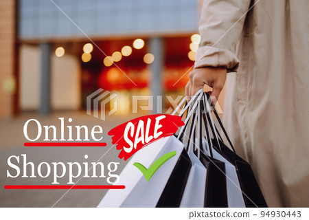 Young woman with shopping bags near mall. Spring Style. Consumerism, purchases, shopping, lifestyle. 94930443