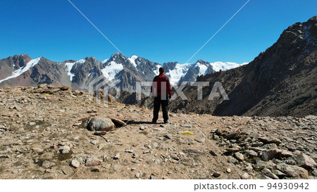 The guy looks at mountains and snow-capped peaks 94930942