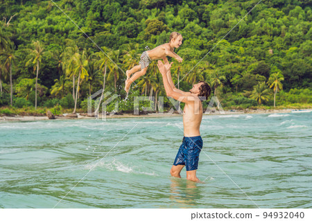 Dad plays with his son in the sea Dad plays with his son in the sea 94932040