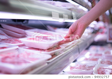 Female customer's hand holding meat in supermarket 94932757