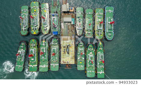 Aerial view group of tug boats, Tugboat  in the sea water area of the port. Preparing to maneuver  large ship . 94933023