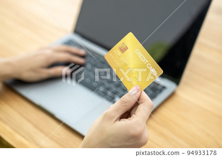 Asian Woman holding bank business credit card with computer laptop, Woman hand holding bank credit card, Paying using credit card, Asian shopaholic shopping online lifestyle. Asian Woman holding bank business credit card with computer laptop, Woman hand holding bank credit card, Paying using credit card, Asian shopaholic shopping online lifestyle. 94933178