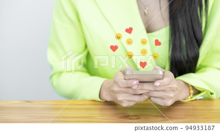Close up Asian woman in green suit pastel holding and using smart phone, Asian woman using smartphone choosing item in marketplace on store website with virtual interface shopping online technology. 94933187