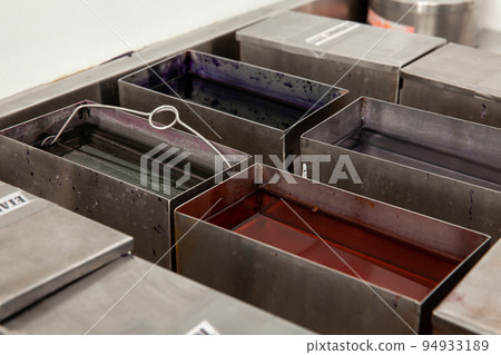Scientist staining microscope slides for cytology studies in the laboratory. Fixation of samples through ethanol bathing. 94933189
