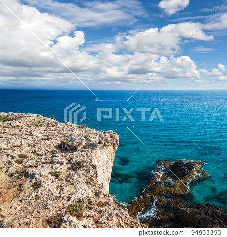Coastal view with rocks and sea water under cloudy sky 94933393