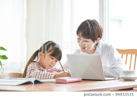 Mother working from home and daughter studying Mother working from home and daughter studying 94933535