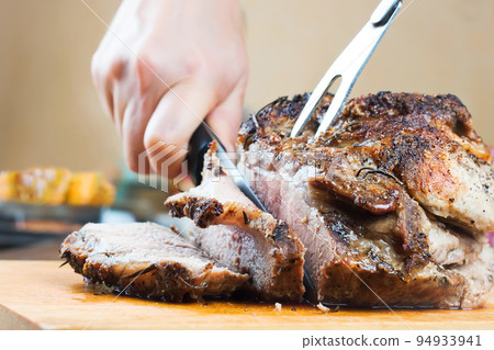 Baked pork meat with spices on wooden cutting board 94933941