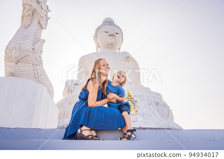 Mother and son tourists on the Big Buddha statue. Was built on a high hilltop of Phuket Thailand Can be seen from a distance Mother and son tourists on the Big Buddha statue. Was built on a high hilltop of Phuket Thailand Can be seen from a distance 94934017