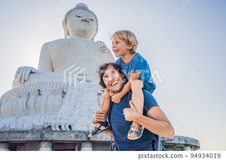 Father and son tourists on the Big Buddha statue. Was built on a high hilltop of Phuket Thailand Can be seen from a distance Father and son tourists on the Big Buddha statue. Was built on a high hilltop of Phuket Thailand Can be seen from a distance 94934019