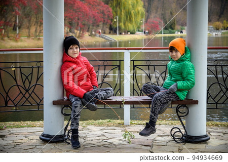 Two siblings stand on the bridge and admire the magnificent view Two siblings stand on the bridge and admire the magnificent view 94934669